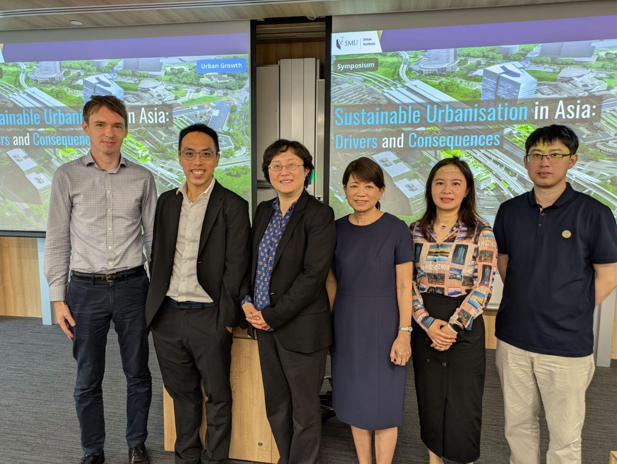 research presenters standing in row beside projector screens